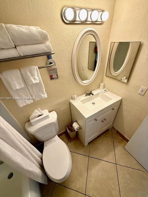 bathroom featuring tile patterned flooring, vanity, and toilet