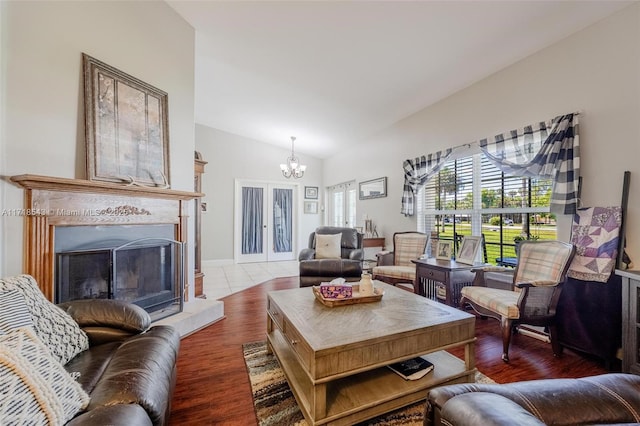 living room with an inviting chandelier, lofted ceiling, and hardwood / wood-style floors