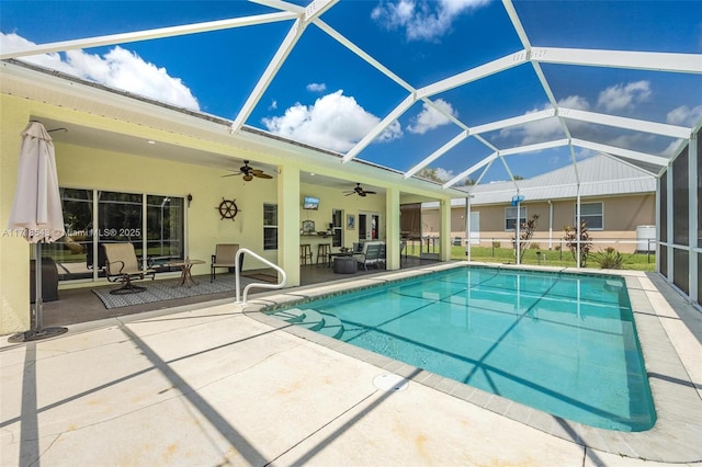 view of swimming pool featuring ceiling fan, glass enclosure, and a patio