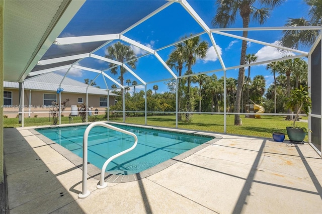 view of pool with a patio area, a lawn, and glass enclosure