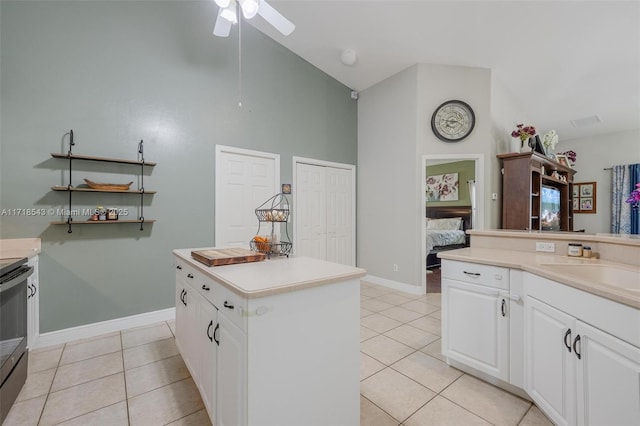 kitchen with white cabinetry, high vaulted ceiling, light tile patterned floors, a kitchen island, and ceiling fan