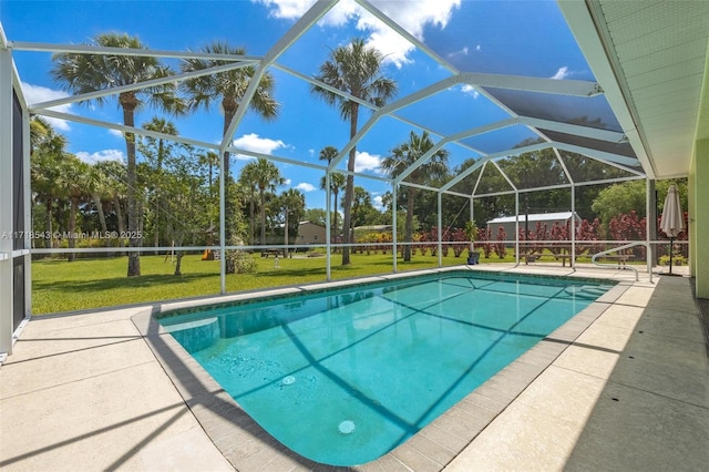 view of pool featuring a lawn, a patio, and glass enclosure