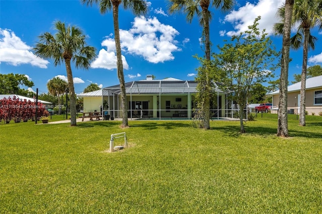 back of house with a yard and a lanai