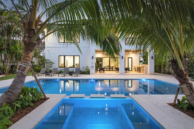 view of swimming pool featuring a patio area and an in ground hot tub