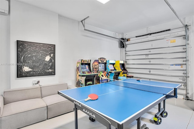 recreation room with concrete floors and an AC wall unit