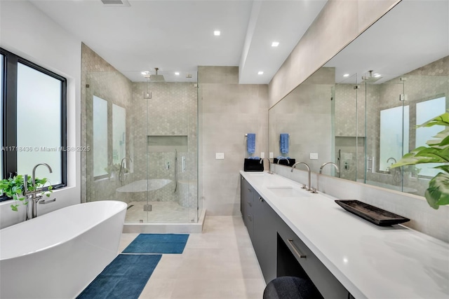 bathroom featuring vanity, shower with separate bathtub, plenty of natural light, and tile walls