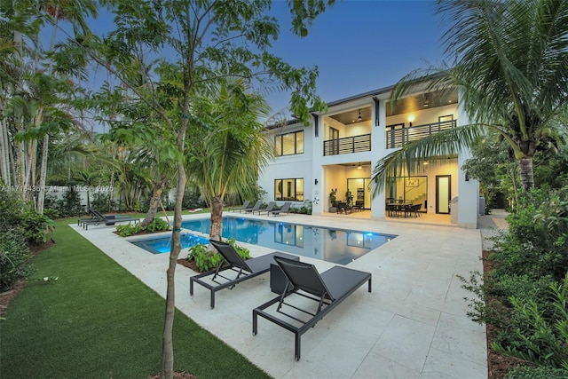 view of pool with a lawn, ceiling fan, and a patio