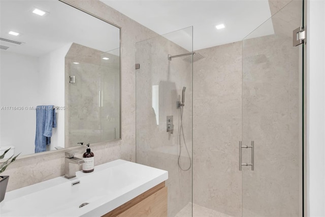 bathroom featuring vanity and a shower with shower door