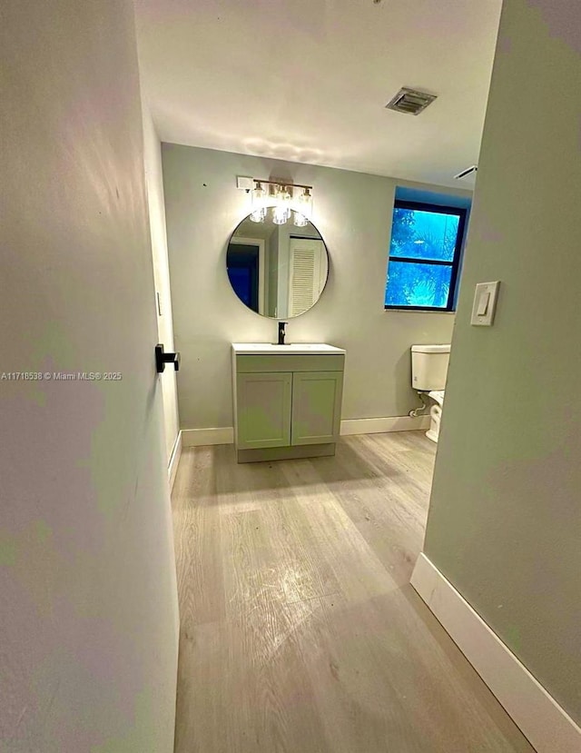 bathroom featuring hardwood / wood-style flooring, vanity, and toilet