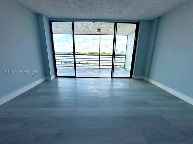 empty room featuring a wall of windows and a textured ceiling