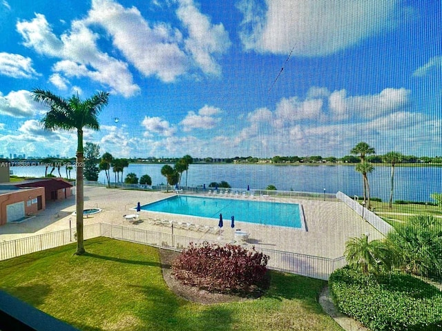 view of swimming pool featuring a yard and a water view