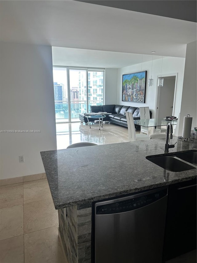 kitchen featuring dishwasher, light tile patterned flooring, dark stone counters, and sink