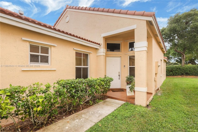 doorway to property with a yard