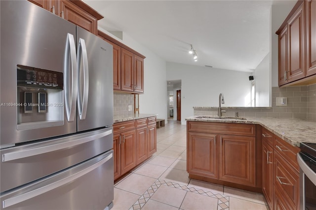 kitchen featuring light stone countertops, backsplash, stainless steel appliances, sink, and light tile patterned flooring