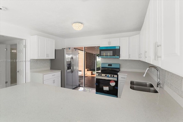 kitchen with tasteful backsplash, sink, white cabinets, and stainless steel appliances