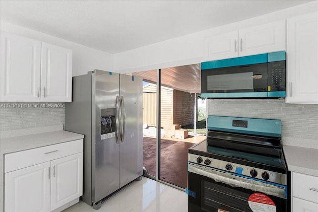 kitchen with backsplash, white cabinetry, light tile patterned flooring, and appliances with stainless steel finishes