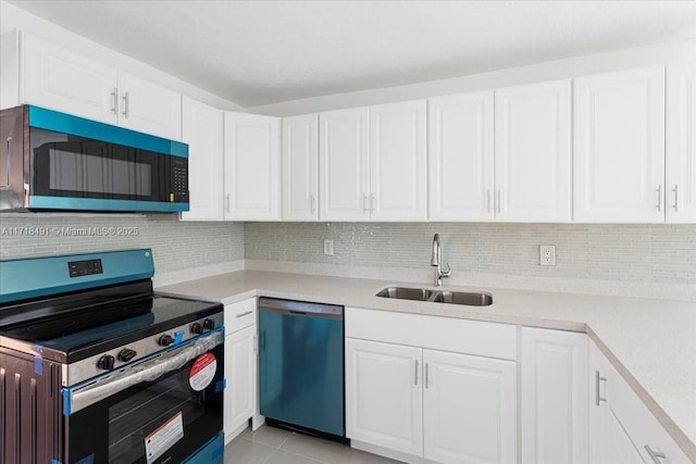 kitchen featuring backsplash, white cabinets, sink, light tile patterned floors, and appliances with stainless steel finishes