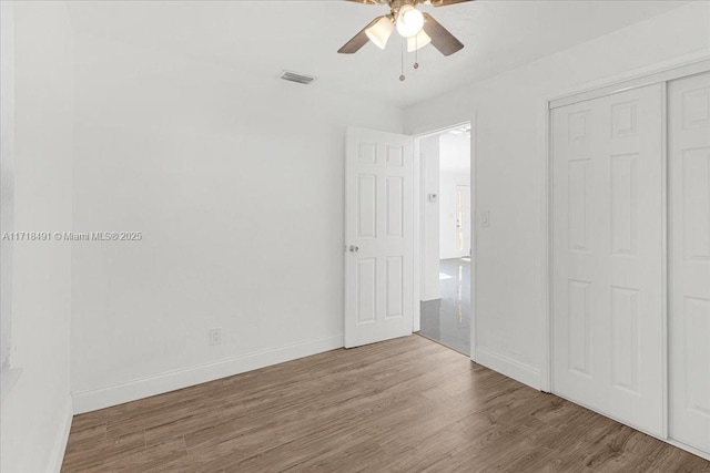 unfurnished bedroom featuring wood-type flooring, a closet, and ceiling fan