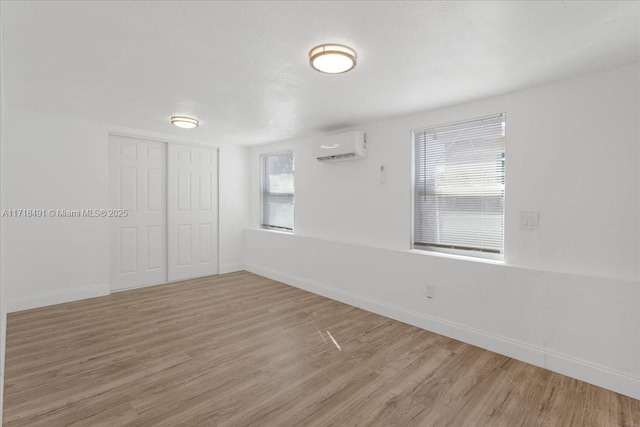 empty room with wood-type flooring and a wall mounted AC