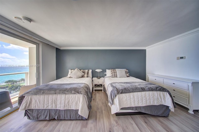 bedroom featuring crown molding, a water view, and light hardwood / wood-style floors