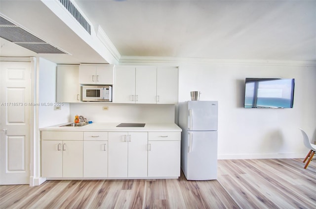 kitchen with white appliances, sink, crown molding, light hardwood / wood-style floors, and white cabinetry