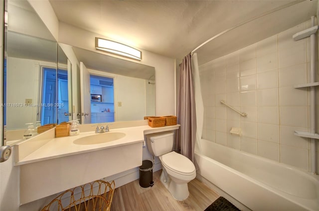 full bathroom with hardwood / wood-style floors, vanity, shower / tub combo, and toilet