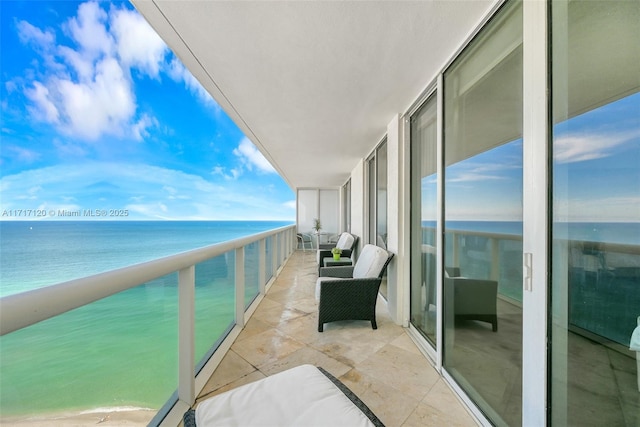 balcony featuring a water view and a beach view