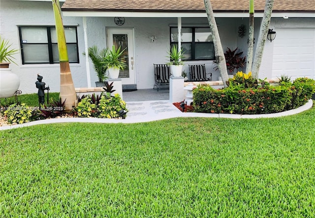 property entrance with covered porch, a garage, and a lawn