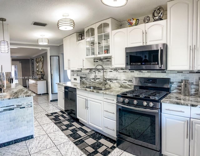 kitchen featuring light stone countertops, white cabinetry, sink, stainless steel appliances, and decorative light fixtures