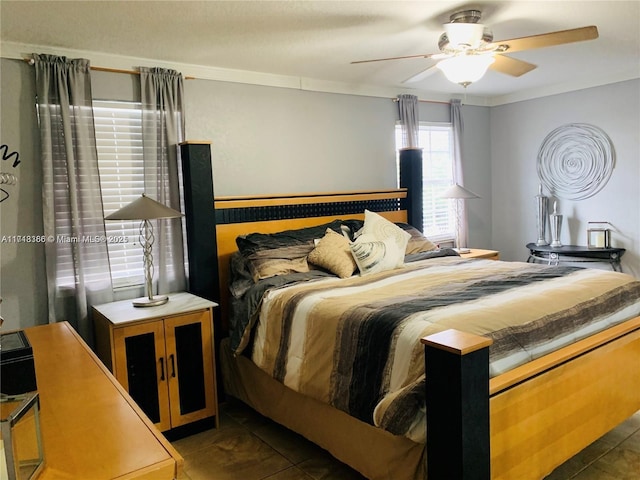 tiled bedroom with ceiling fan and ornamental molding