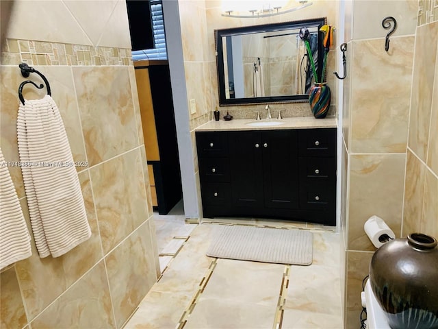 bathroom featuring vanity and tile walls