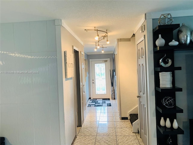 corridor featuring a chandelier, a textured ceiling, and crown molding