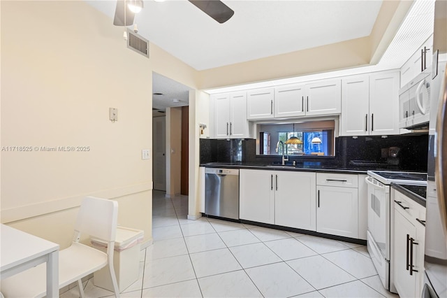 kitchen with white appliances, ceiling fan, tasteful backsplash, light tile patterned flooring, and white cabinetry