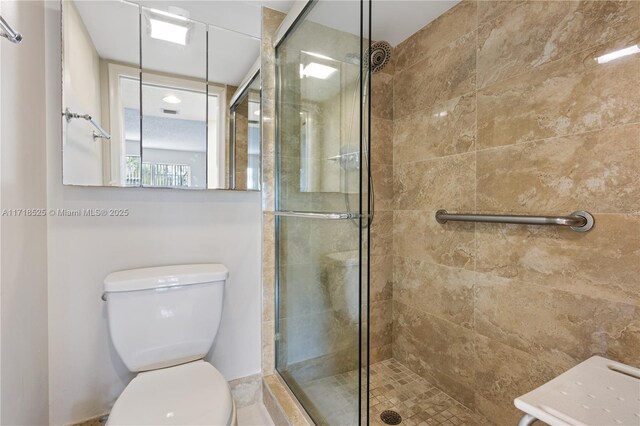 bathroom featuring an enclosed shower and toilet