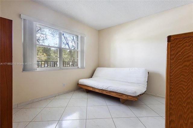 sitting room featuring light tile patterned floors and a textured ceiling