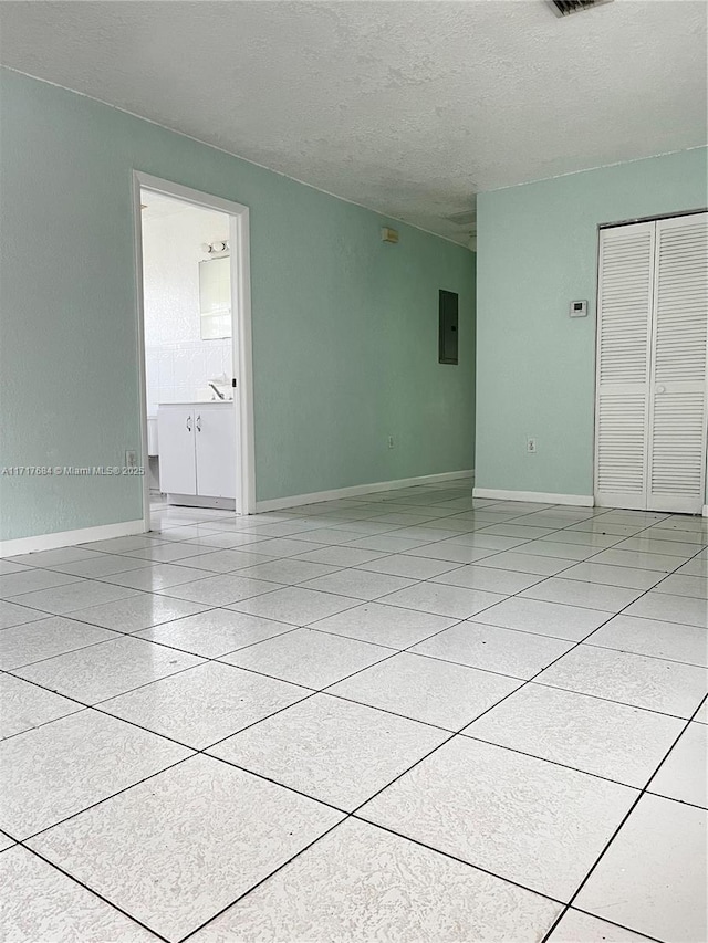 unfurnished room with a textured ceiling and electric panel