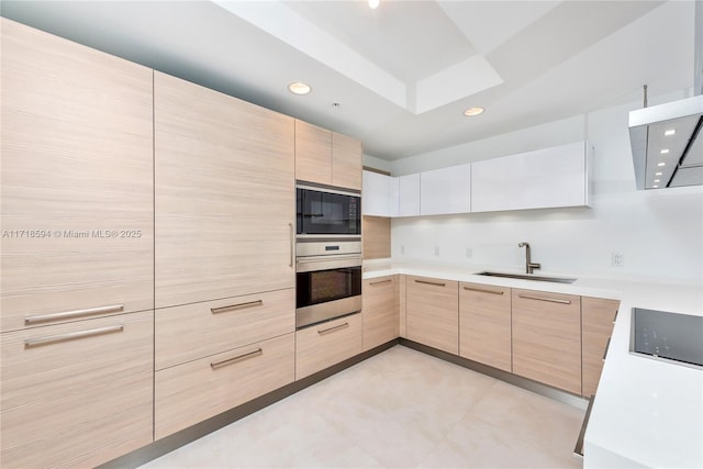 kitchen with black microwave, sink, stovetop, oven, and light brown cabinetry