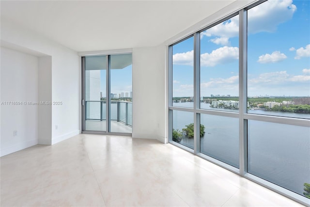 empty room with a water view, a wall of windows, and a wealth of natural light