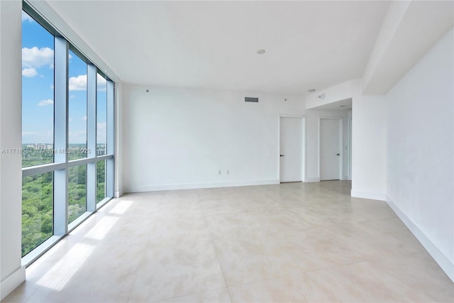 unfurnished room with a wall of windows