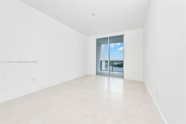 tiled spare room featuring floor to ceiling windows