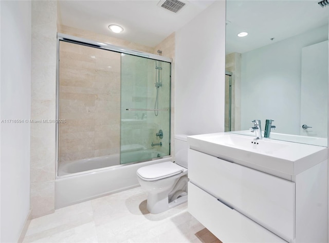 full bathroom featuring shower / bath combination with glass door, vanity, and toilet