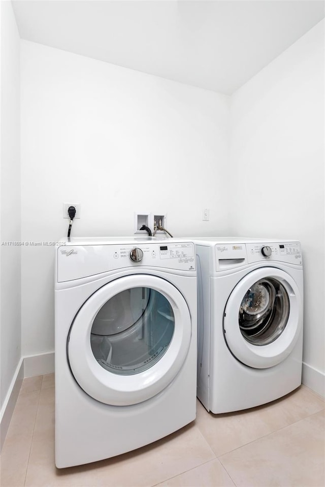 washroom featuring light tile patterned flooring and washing machine and clothes dryer