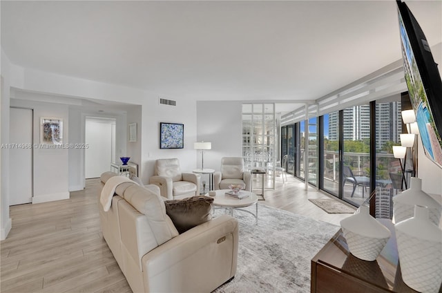 living room with light hardwood / wood-style floors and floor to ceiling windows