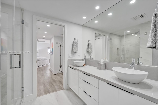 bathroom featuring vanity and a shower with door