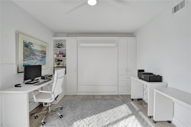 home office with light hardwood / wood-style floors