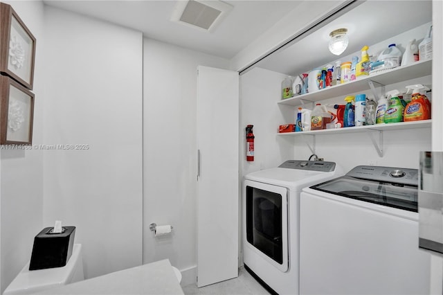 laundry room with washer and clothes dryer and light tile patterned flooring