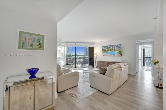 living room with plenty of natural light, expansive windows, and light hardwood / wood-style floors