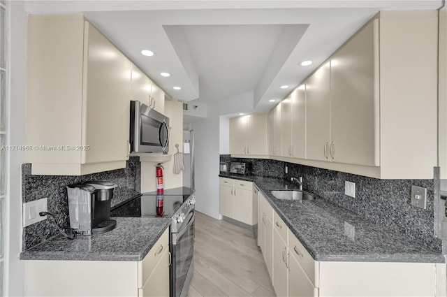 kitchen featuring backsplash, light hardwood / wood-style floors, sink, and stainless steel appliances