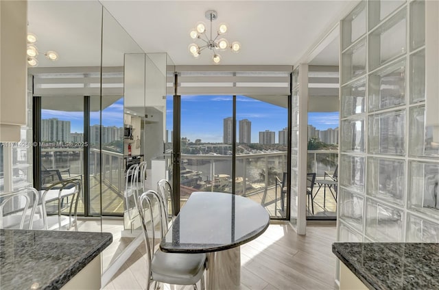 dining room featuring light hardwood / wood-style flooring, expansive windows, and a notable chandelier