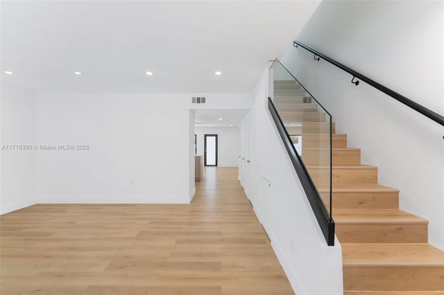 stairs featuring hardwood / wood-style flooring